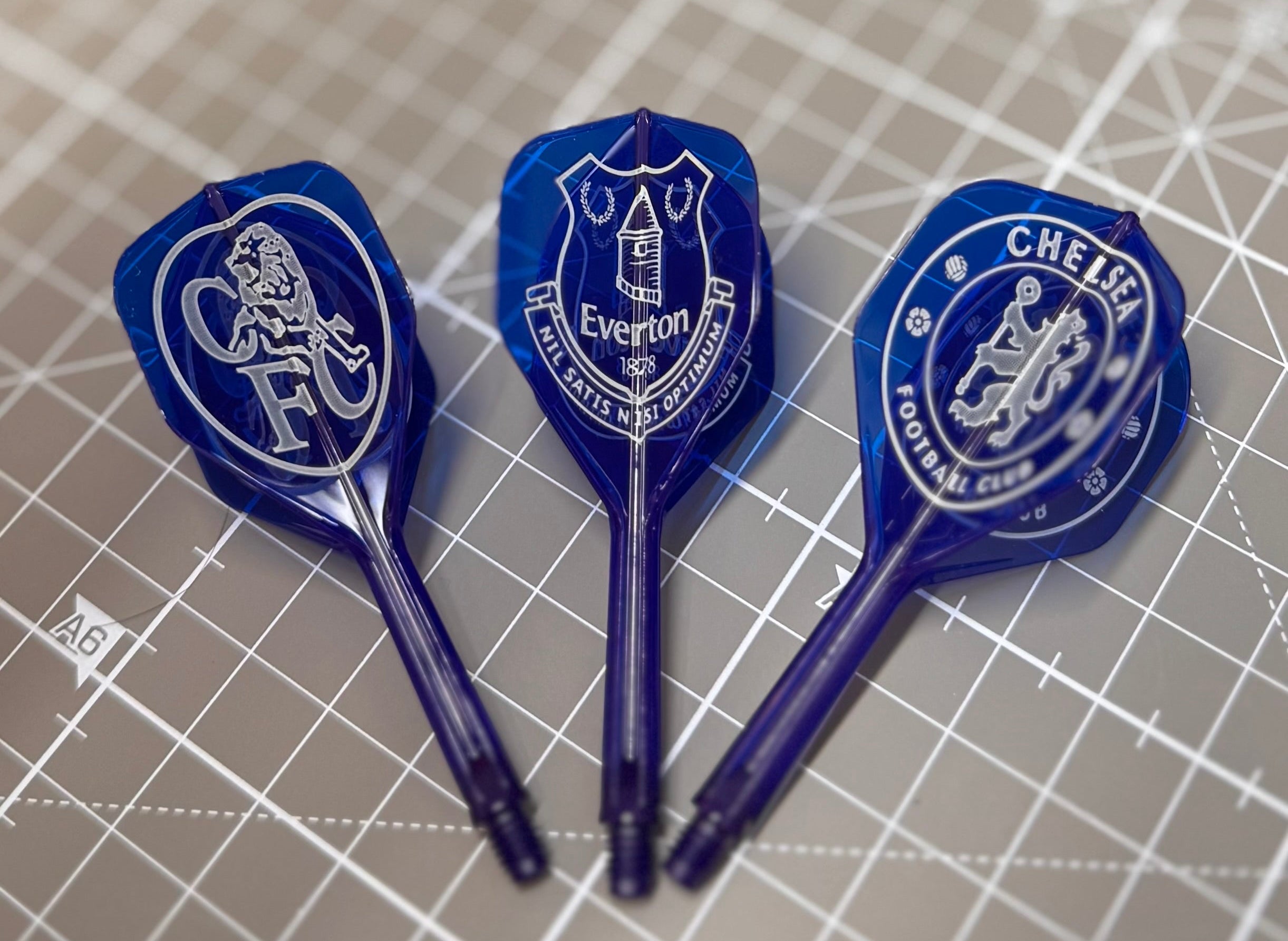 Three blue darts with Everton FC logo on a grid surface